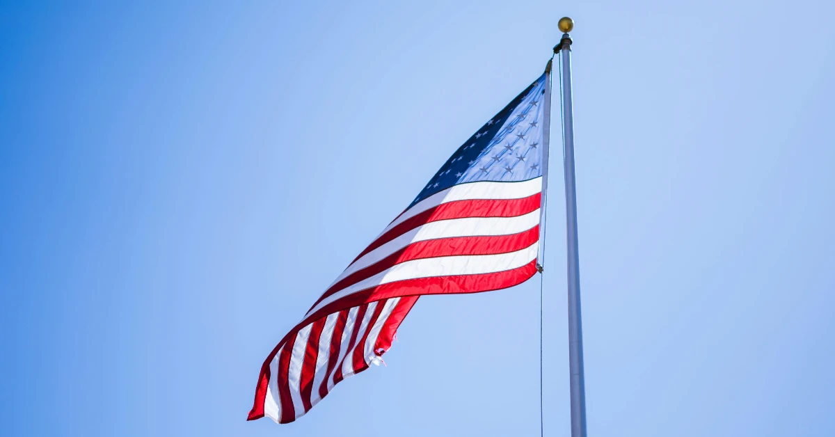 American flag flying against a clear blue sky, symbolizing U.S. military service and veteran legacy